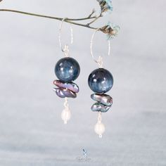 These unique Kyanite bead natural stone dangle drop earrings feature a beautiful 12 mm Kyanite stone bead, two irregular long blue pearls and a freshwater rice pearl dangle drop at the end. The ear wires are made from solid 925 sterling silver with texture diamond cut to maximum light refection. Add these unique Kyanite bead and pearls drop earrings to your everyday gemstone jewelry collection or as a gift for your loved one. Materials: 925 sterling silver, Kyanite, freshwater blue pearls, rice Blue Pearls, Blue Pearl, Pearl Drop Earrings, Natural Beads, Pearl Drop, Diamond Cut, Solid 925 Sterling Silver, Ear Wires, Stone Beads