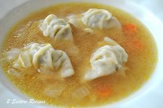 some dumplings are sitting in a bowl of soup