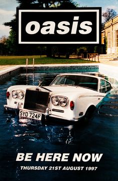 an advertisement for oasis featuring a white car in the middle of water with a sign reading, be here now