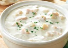 a white bowl filled with soup next to bread