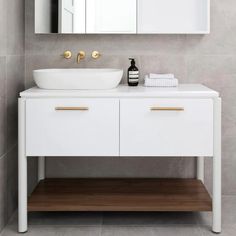 a white sink sitting under a bathroom mirror