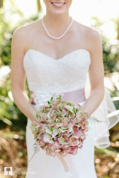 a woman in a wedding dress holding a bridal bouquet