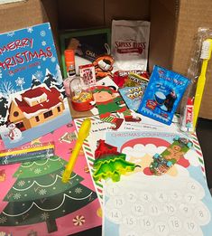 the contents of a christmas gift box are shown in front of an open cardboard box