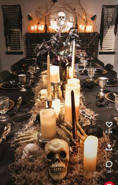 a table topped with candles and skulls on top of it's black table cloth