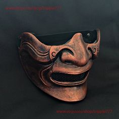 an old mask is sitting on a black surface