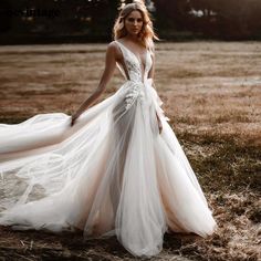 a woman in a wedding dress standing on the grass