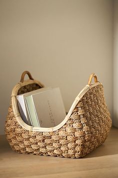 a wicker basket with books in it sitting on a table