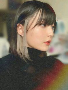 a woman with long hair and bangs wearing a black turtle neck sweater looking off to the side