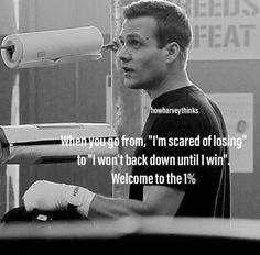 a man with gloves on standing in front of a sign that says, when you drop iron, i'm scared of losing to won't back down until i win