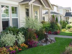 the front yard is full of flowers and plants