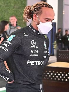 a man with dreadlocks wearing a face mask