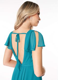 the back of a woman wearing a teal blue dress with open shoulder and tie detail