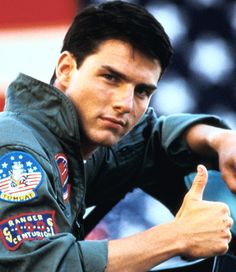 a man in an air force uniform giving the thumbs up sign with his right hand