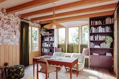 a dining room table and chairs with bookshelves in the background