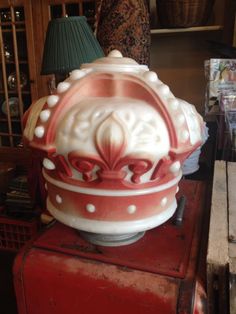 a red and white lamp sitting on top of a table