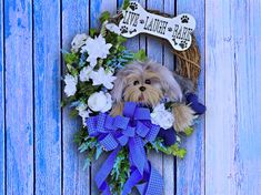 a dog is sitting in the middle of a wreath with flowers and a bone on it