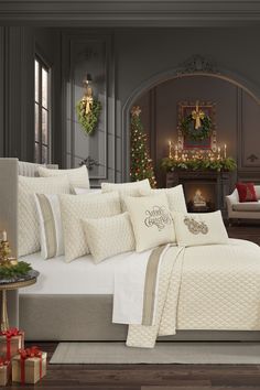 a white bed sitting in a bedroom next to a christmas tree with presents on it