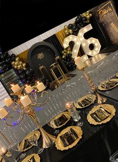 the table is set with black and gold decorations