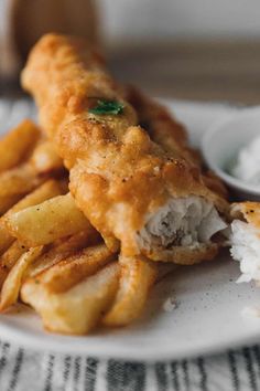 some fried food on a white plate with dipping sauce