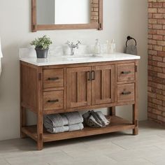 a bathroom with a sink, mirror and towels on the rack in front of it