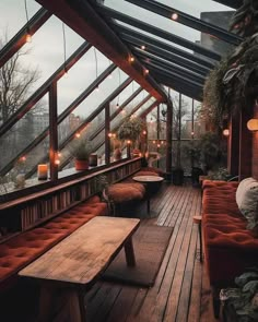 a room filled with lots of furniture and plants on top of wooden floored walls