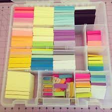 a plastic container filled with lots of different colored sticky notes