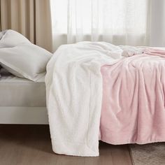 a bed covered in pink and white blankets