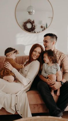 a man and woman sitting on a couch with two children