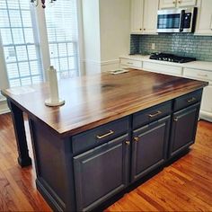 a large kitchen island in the middle of a wooden floor