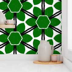 a green and white wallpaper with black lines in the shape of clover leaves on it