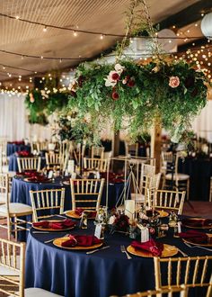 tables with blue linens and gold chairs are set up for an elegant wedding reception