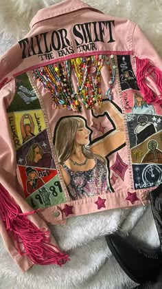 a pink jacket with pictures on it and fringes around the neck, sitting on top of a white furnishing