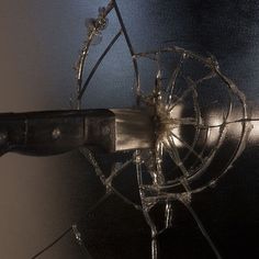 a broken fan is hanging on the wall in front of a mirror with barbed wire attached to it