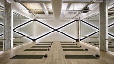 yoga mats are lined up in the middle of a room with mirrors on the wall