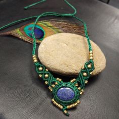 This Macrame Necklace is Handmade from Waxed Cotton Yarn, Brass Bead of Different Sizes and Gemstone. In the Center is a Beautiful Cabochon of Lapis Lazuli Set in Macramé and Enhanced with Brass Beads. This Necklace is Adjustable by sliding and You Can Adjust Its Length According to Your Desire Choker, Classic Or Long Necklace - Wire Color: Green -Necklace length: Adjustable max 36 cm - Stone: Lapis Lazuli -Stone Shape: Oval - Stone diameter: 2 cm -Properties of the Stone: offers a certain ease Handmade Lapis Lazuli Jewelry For Festivals, Blue Round Pendant Necklace For Festivals, Bohemian Lapis Lazuli Round Necklaces, Blue Lapis Lazuli Jewelry For Festivals, Lapis Lazuli Pendant Beaded Necklace As Gift, Beaded Lapis Lazuli Pendant Jewelry, Lapis Lazuli Beaded Pendant Jewelry, Lapis Lazuli Pendant Beaded Necklace For Gifts, Adjustable Lapis Lazuli Pendant Necklace