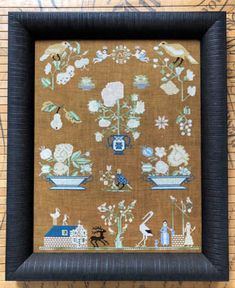 a cross stitch pattern with flowers and birds in blue vases on a brown background