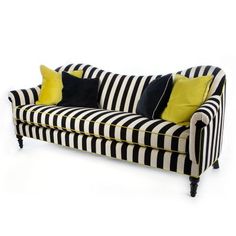 a black and white striped couch with yellow pillows on it's backrests