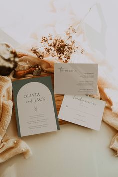 the wedding stationery is laid out on top of an unbuttoned blanket