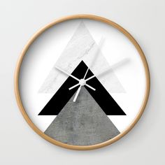 a white clock with black and grey triangles on it