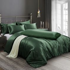 a bed with green sheets and pillows in a room