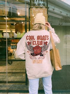 ✺ COOL AUNTS CLUB SWEATSHIRT ✺ * Q U I C K F A C T S * This design is a unique illustration that has been created in house. ✺ 50% Cotton 50% Polyester ✺ Medium-heavy fabric (8.0 oz/yd² (271.25 g/m ✺ Sizing is unisex so runs like men's, though not overly large ✺ Most women find their typical size works best, since they are meant to fit a touch loose Please note that colours may appear different on different digital screens and may not be a true representation of the actual colours. * EXCHANGES / Cool Graphic Print Crew Neck Sweatshirt, Cool Crew Neck Tops For Winter, Cool Cotton Crew Neck Sweatshirt, Cool Crew Neck Winter Sweatshirt, Cool Sweatshirt With Letter Print, Winter College Style T-shirt With Graphic Print, Cool Long Sleeve Relaxed Fit Tops, Cool Relaxed Fit Long Sleeve Tops, Relaxed Fit Long Sleeve Casual Top