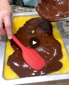 a person spreading chocolate on top of a cake