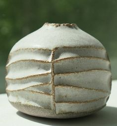 a white vase sitting on top of a table