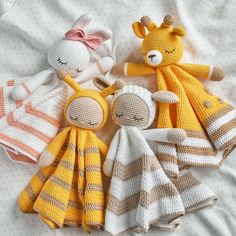 three knitted stuffed animals are laying on a bed with white sheets and polka dots