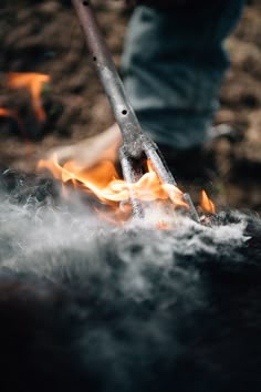 a person holding a large metal object with flames coming out of it