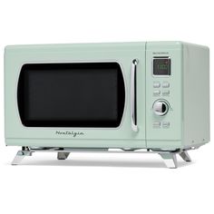 a light green microwave oven sitting on top of a white counter next to a clock