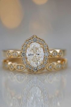 a yellow gold engagement ring with an oval cut diamond in the center and pave diamonds around it