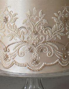 a cake with white frosting and beading on it