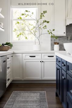 a kitchen with white cabinets and dark blue drawers is featured in the wildwood home co catalog