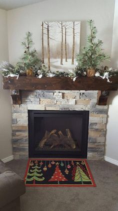 a living room with a fire place and christmas decorations on the mantel above it